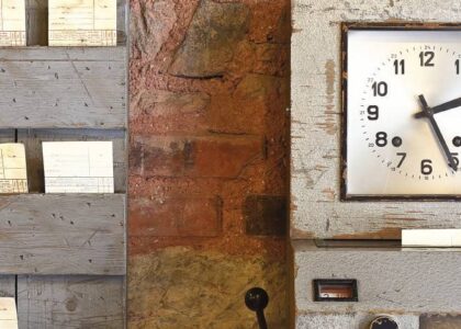 Antique time stamp clock in papers and clock face against a rustic brick wall