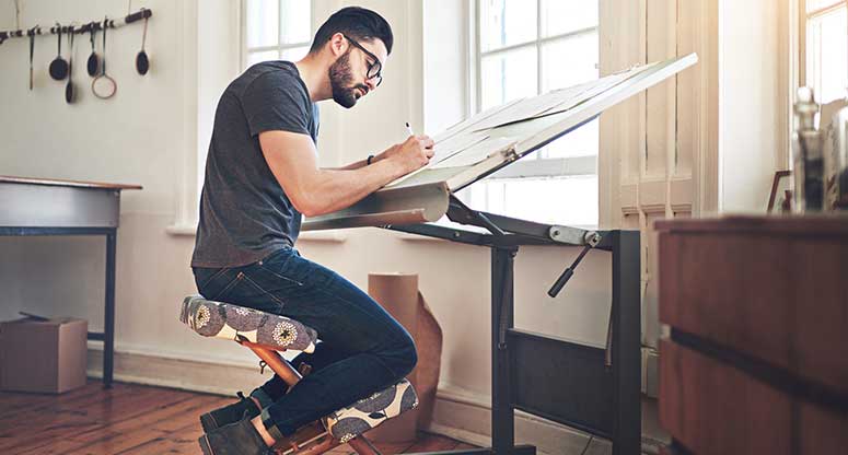man working on drafting table creative 