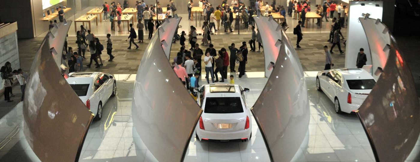indoor showroom with cars and people