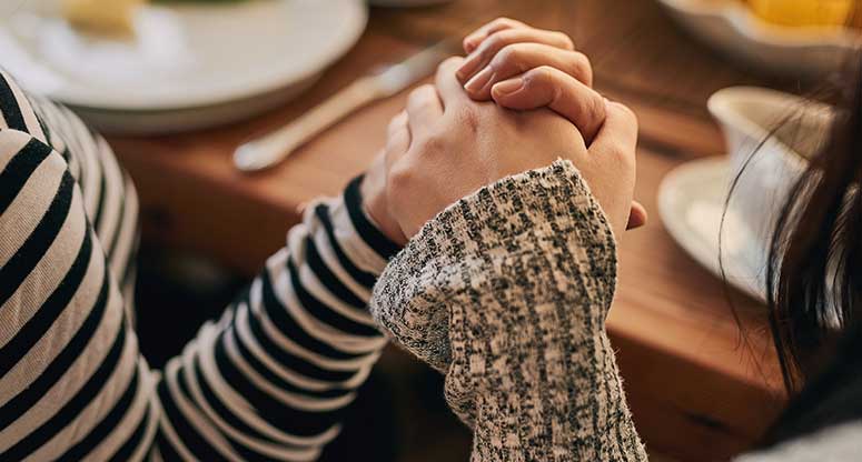 two people holding hands on a thanksgiving table
