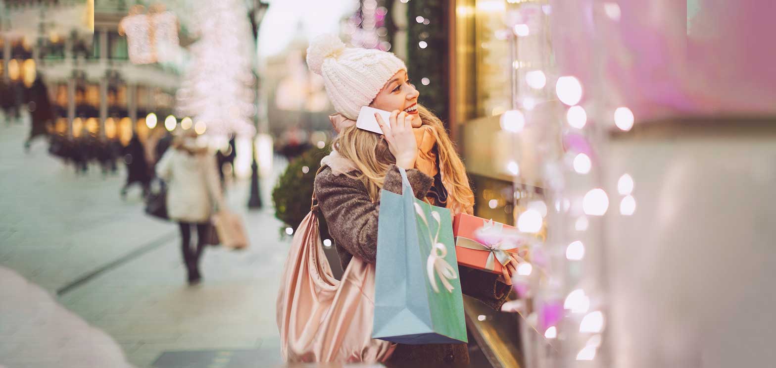 woman talking on the phone shopping during the holidays