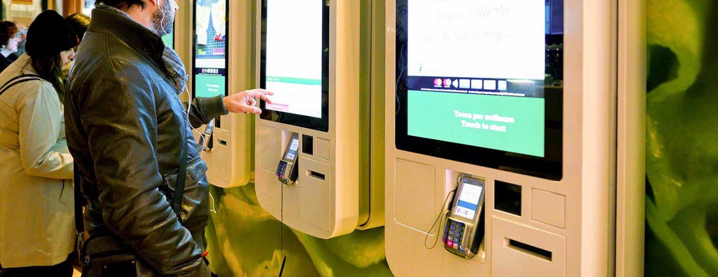 people using self service computers to order fast food items