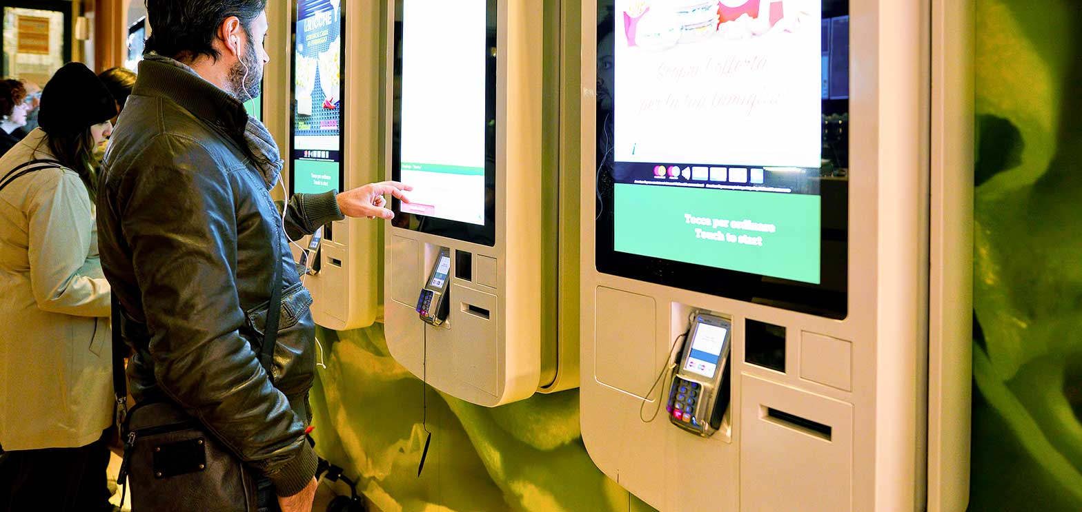 people using self service computers to order fast food items