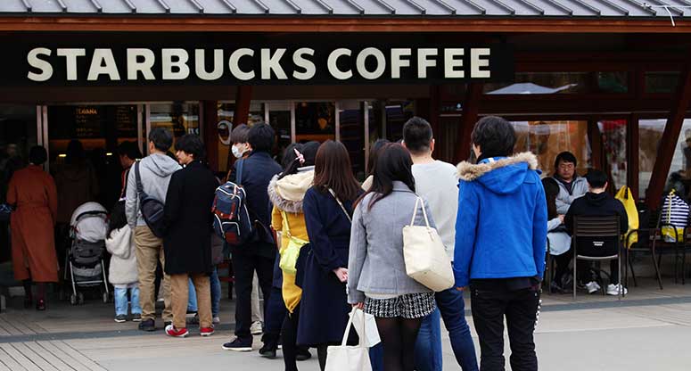 people waiting in line for coffee at a Starbucks loyal customers to brand