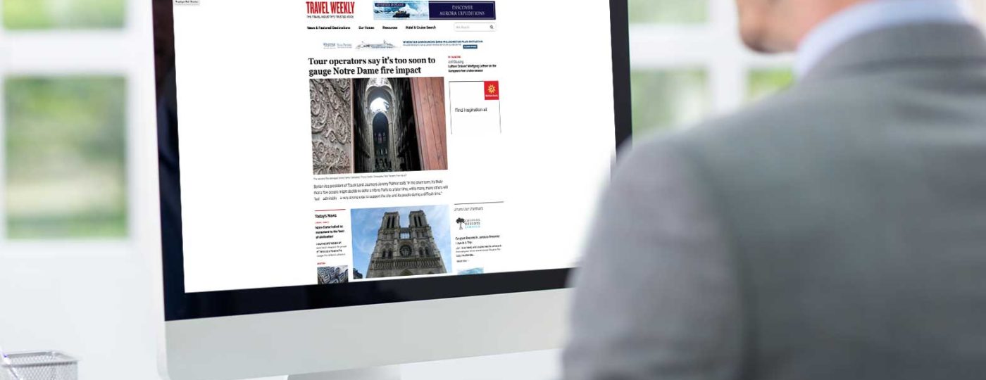 man looking at computer screen with travel weekly website