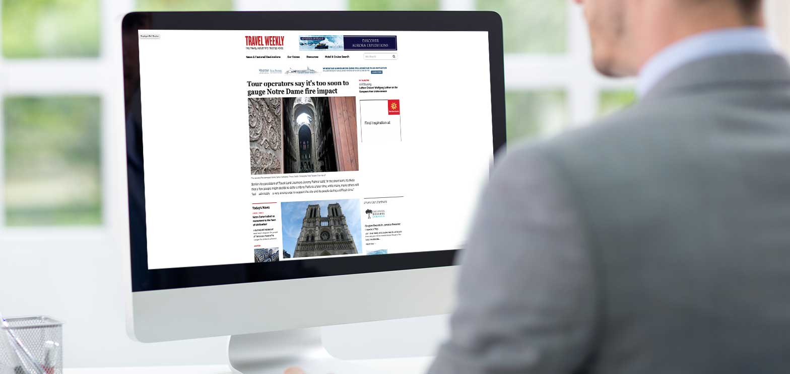 man looking at computer screen with travel weekly website