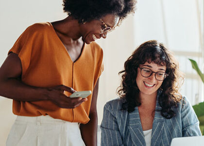 Two female entrepreneurs using a laptop for a productive business meeting.