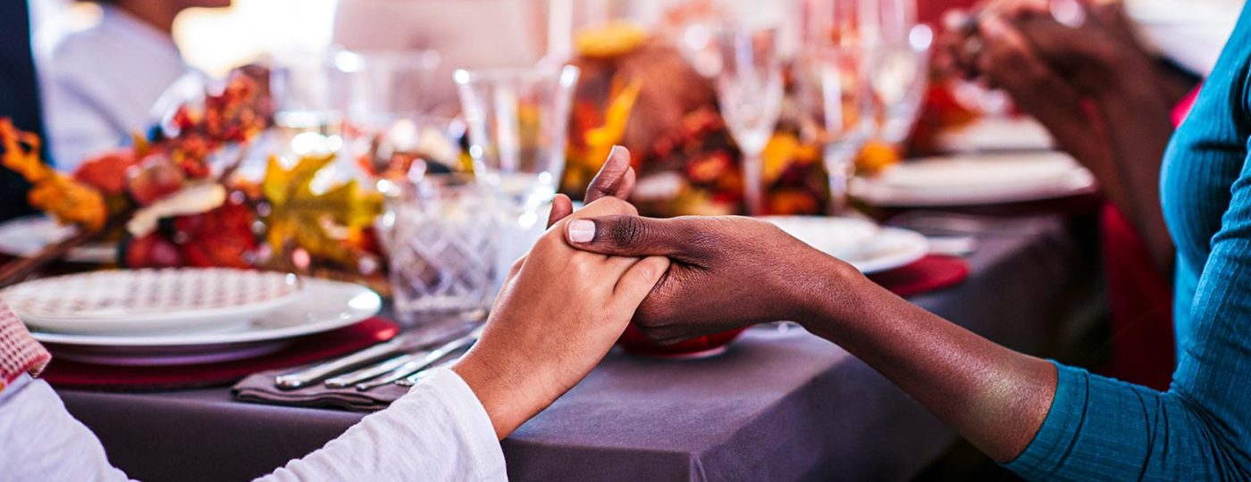 people holding hands during Thanksgiving dinner