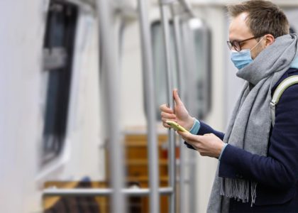 man on the subway with a mask talking to on demand contact center customer service agent