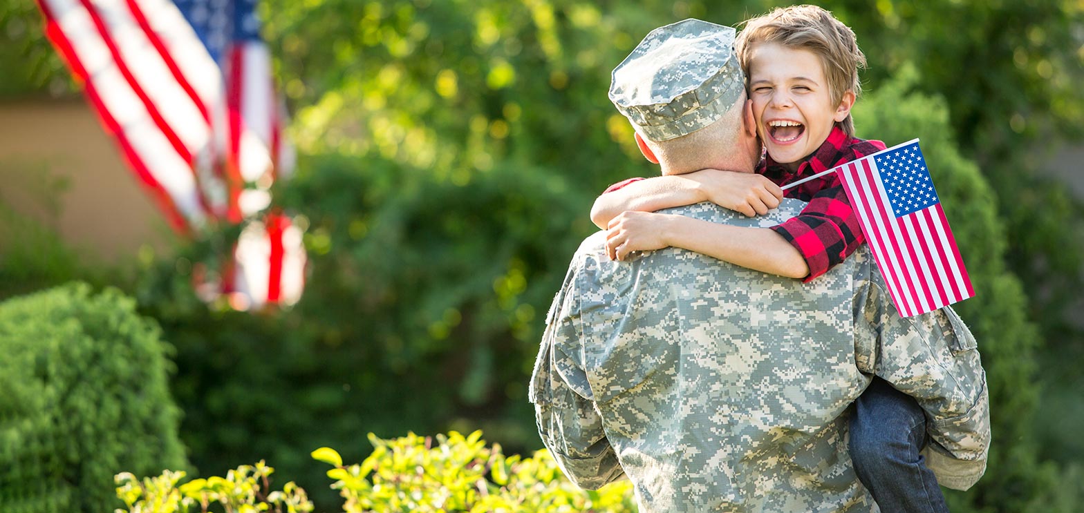 military dad hugging his kid after being deployed