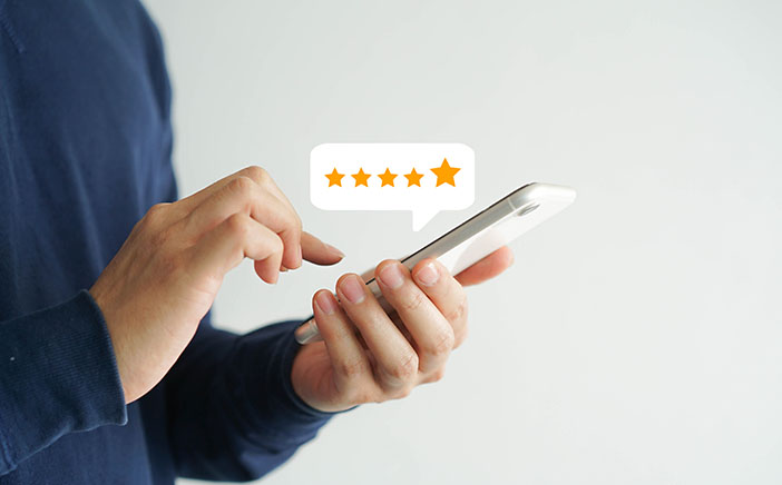 Person holding a phone with an illustrated quote bubble that depicts a 5 star rating