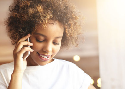 Black woman looking down while on the phone
