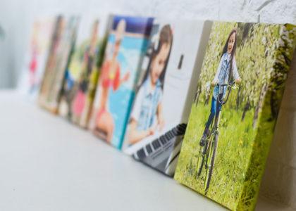 Canvas-printed photographs in a row on the mantle of a clean white indoor room