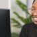 Young professional Black customer service agent smiling in her home office