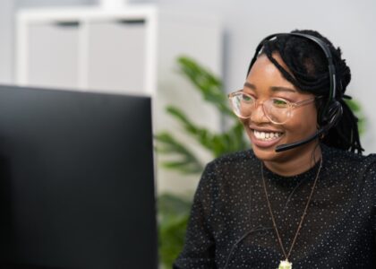 Young professional Black customer service agent smiling in her home office