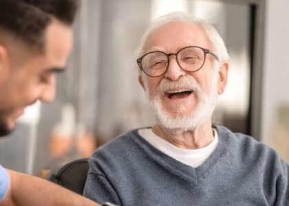 Joyful senior man laughs with caretaker