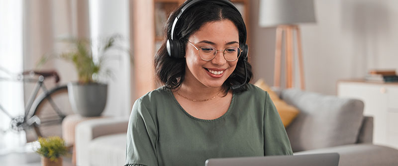 Thrilled agent talks to customer via headset in her living room