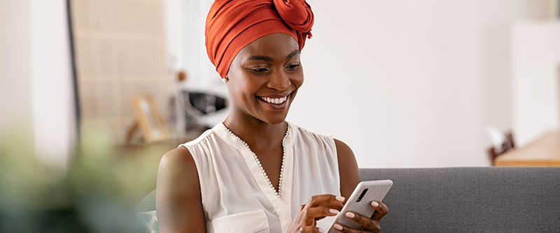 Happy customer smiles at her phone as she receives wonderful customer care