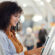 Happy customer at airport operates automatic ticket kiosk