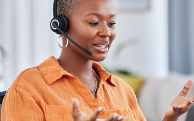 Work from home agent talks joyfully with a customer through her headset