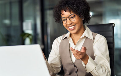 Happy professional young female HR manager converses digitally with an interviewee in an office setting