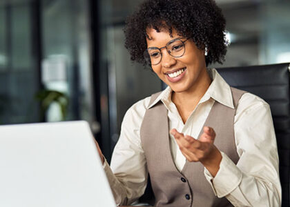 Happy professional young female HR manager converses digitally with an interviewee in an office setting