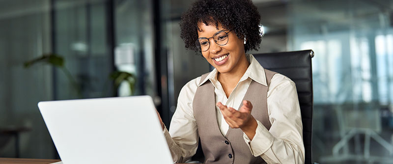 Happy professional young female HR manager converses digitally with an interviewee in an office setting