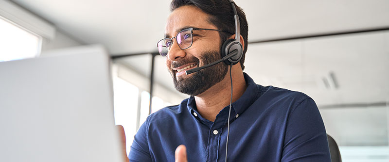 Knowledgable male customer experience agent talks enthusiastically with customer on the phone