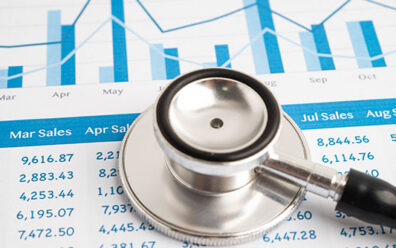 Stethoscope laying on top of a paper that displays medical sales numbers by month